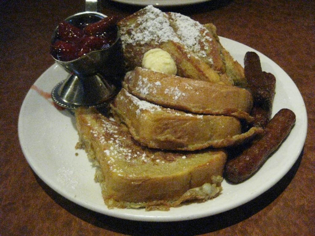 French toast with a side of strawberry sauce and sausage. The Broken Yolk Cafe serves generous portions. Michelle Moran, City Times.