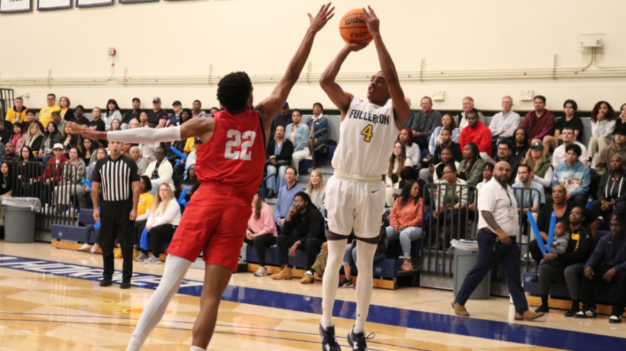 Knights guard Logan Huston, left, dividing three point shot by Fullerton College guard Sean Newman Jr. , right, Photo courtesy of Fullerton College Athletics