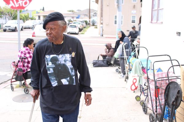 El cofundador de la sede regional de Black Panthers de San Diego, Jeffery Jennings, de 75 años, ingresa al Elks Lodge en la esquina de calle Comercial y Hensley después de hablar con los destinatarios que esperan a que comience la entrega de alimentos el miércoles 16 de abril de 2025. Fotografía de Tresean Osgood/City Times Media
